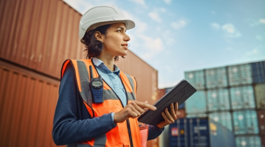 person using tablet in shipping yard